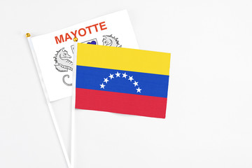 Venezuela and Mayotte stick flags on white background. High quality fabric, miniature national flag. Peaceful global concept.White floor for copy space.