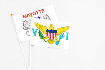 United States Virgin Islands and Mayotte stick flags on white background. High quality fabric, miniature national flag. Peaceful global concept.White floor for copy space.