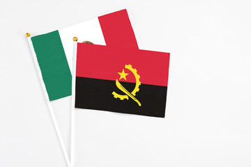Angola and Mexico stick flags on white background. High quality fabric, miniature national flag. Peaceful global concept.White floor for copy space.