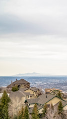 Obraz premium Vertical Aerial view of houses in the valley with mountain and horizon in the distance