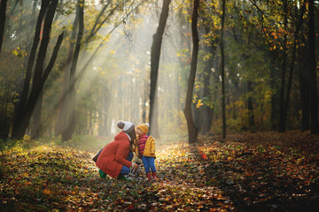 Mother and daughter walking in the Park and enjoying the beautiful autumn nature.