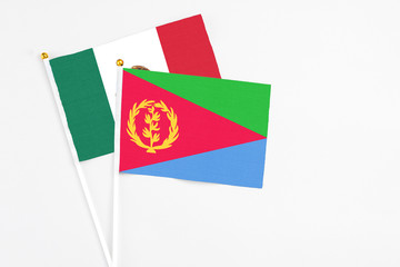 Eritrea and Mexico stick flags on white background. High quality fabric, miniature national flag. Peaceful global concept.White floor for copy space.