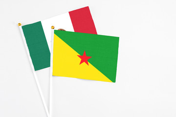 French Guiana and Mexico stick flags on white background. High quality fabric, miniature national flag. Peaceful global concept.White floor for copy space.