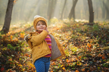 adorable happy girl playing in autumn fairy tale forest