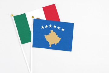 Kosovo and Mexico stick flags on white background. High quality fabric, miniature national flag. Peaceful global concept.White floor for copy space.