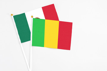 Mali and Mexico stick flags on white background. High quality fabric, miniature national flag. Peaceful global concept.White floor for copy space.