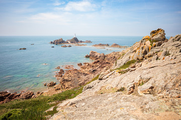 Fototapeta na wymiar Perched on a rock in the sea, the dramatic location of the Corbière lighthouse on the extreme southwestern tip of Jersey