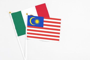 Malaysia and Mexico stick flags on white background. High quality fabric, miniature national flag. Peaceful global concept.White floor for copy space.