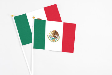 Mexico and Mexico stick flags on white background. High quality fabric, miniature national flag. Peaceful global concept.White floor for copy space.