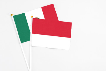 Monaco and Mexico stick flags on white background. High quality fabric, miniature national flag. Peaceful global concept.White floor for copy space.