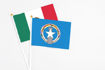Northern Mariana Islands and Mexico stick flags on white background. High quality fabric, miniature national flag. Peaceful global concept.White floor for copy space.
