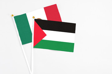 Palestine and Mexico stick flags on white background. High quality fabric, miniature national flag. Peaceful global concept.White floor for copy space.