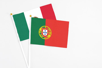 Portugal and Mexico stick flags on white background. High quality fabric, miniature national flag. Peaceful global concept.White floor for copy space.