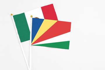 Seychelles and Mexico stick flags on white background. High quality fabric, miniature national flag. Peaceful global concept.White floor for copy space.