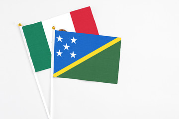 Solomon Islands and Mexico stick flags on white background. High quality fabric, miniature national...