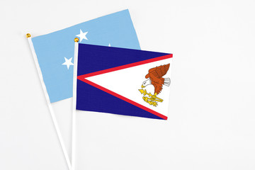 American Samoa and Micronesia stick flags on white background. High quality fabric, miniature national flag. Peaceful global concept.White floor for copy space.