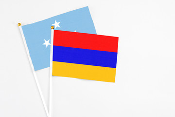 Armenia and Micronesia stick flags on white background. High quality fabric, miniature national flag. Peaceful global concept.White floor for copy space.
