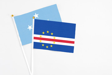 Cape Verde and Micronesia stick flags on white background. High quality fabric, miniature national flag. Peaceful global concept.White floor for copy space.