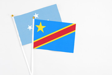 Congo and Micronesia stick flags on white background. High quality fabric, miniature national flag. Peaceful global concept.White floor for copy space.