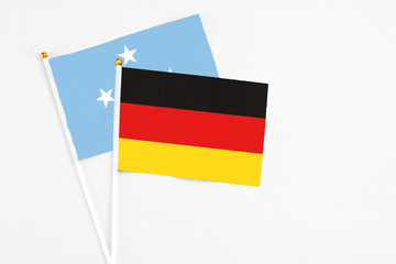 Germany and Micronesia stick flags on white background. High quality fabric, miniature national flag. Peaceful global concept.White floor for copy space.