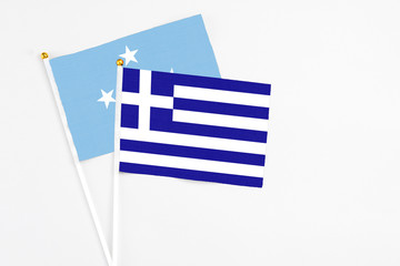 Greece and Micronesia stick flags on white background. High quality fabric, miniature national flag. Peaceful global concept.White floor for copy space.