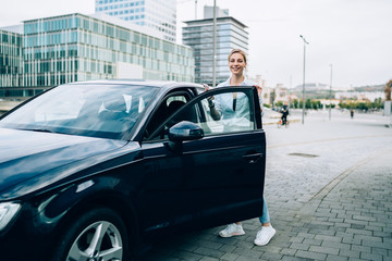 Fototapeta premium Young casual woman with car on street sidewalk