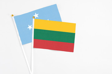 Lithuania and Micronesia stick flags on white background. High quality fabric, miniature national flag. Peaceful global concept.White floor for copy space.