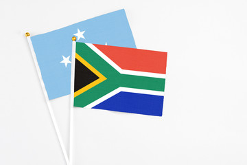 South Africa and Micronesia stick flags on white background. High quality fabric, miniature national flag. Peaceful global concept.White floor for copy space.