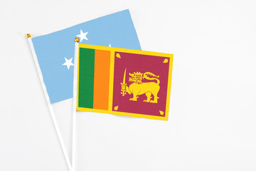 Sri Lanka and Micronesia stick flags on white background. High quality fabric, miniature national flag. Peaceful global concept.White floor for copy space.