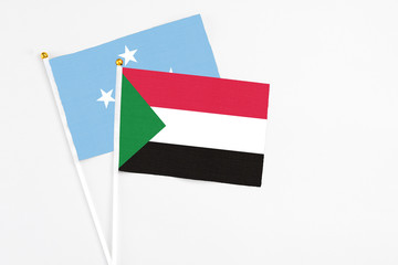 Sudan and Micronesia stick flags on white background. High quality fabric, miniature national flag. Peaceful global concept.White floor for copy space.