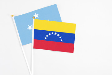 Venezuela and Micronesia stick flags on white background. High quality fabric, miniature national flag. Peaceful global concept.White floor for copy space.