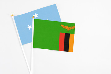 Zambia and Micronesia stick flags on white background. High quality fabric, miniature national flag. Peaceful global concept.White floor for copy space.