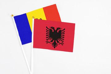Albania and Moldova stick flags on white background. High quality fabric, miniature national flag. Peaceful global concept.White floor for copy space.