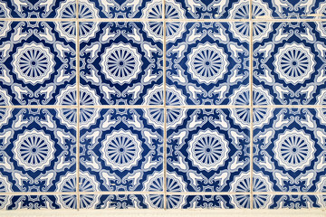 Wall with traditional Portuguese decor tiles azulezhu in blue tones.