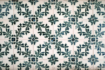 Wall with traditional Portuguese decor tiles azulezhu in green tones.