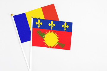 Guadeloupe and Moldova stick flags on white background. High quality fabric, miniature national flag. Peaceful global concept.White floor for copy space.