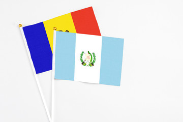 Guatemala and Moldova stick flags on white background. High quality fabric, miniature national flag. Peaceful global concept.White floor for copy space.