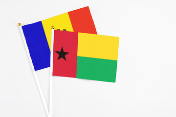 Guinea Bissau and Moldova stick flags on white background. High quality fabric, miniature national flag. Peaceful global concept.White floor for copy space.