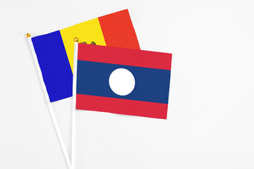 Laos and Moldova stick flags on white background. High quality fabric, miniature national flag. Peaceful global concept.White floor for copy space.