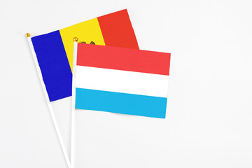 Luxembourg and Moldova stick flags on white background. High quality fabric, miniature national flag. Peaceful global concept.White floor for copy space.