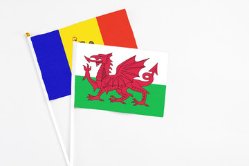 Wales and Moldova stick flags on white background. High quality fabric, miniature national flag. Peaceful global concept.White floor for copy space.