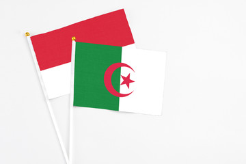 Algeria and Monaco stick flags on white background. High quality fabric, miniature national flag. Peaceful global concept.White floor for copy space.