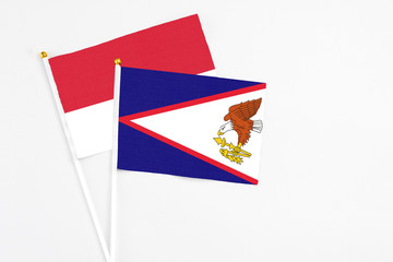 American Samoa and Monaco stick flags on white background. High quality fabric, miniature national flag. Peaceful global concept.White floor for copy space.