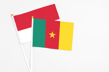 Cameroon and Monaco stick flags on white background. High quality fabric, miniature national flag. Peaceful global concept.White floor for copy space.
