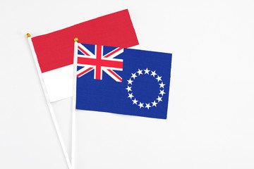 Fototapeta premium Cook Islands and Monaco stick flags on white background. High quality fabric, miniature national flag. Peaceful global concept.White floor for copy space.