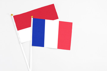 France and Monaco stick flags on white background. High quality fabric, miniature national flag. Peaceful global concept.White floor for copy space.
