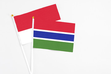 Gambia and Monaco stick flags on white background. High quality fabric, miniature national flag. Peaceful global concept.White floor for copy space.
