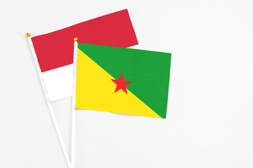 French Guiana and Monaco stick flags on white background. High quality fabric, miniature national flag. Peaceful global concept.White floor for copy space.