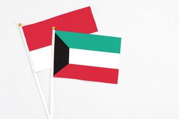 Kuwait and Monaco stick flags on white background. High quality fabric, miniature national flag. Peaceful global concept.White floor for copy space.