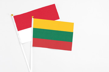 Lithuania and Monaco stick flags on white background. High quality fabric, miniature national flag. Peaceful global concept.White floor for copy space.